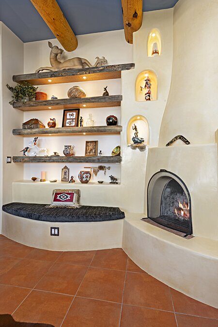 Living Area w/ Wood-burning Kiva Fireplace, built-in, Lighted Shelves and Banco