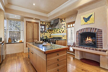Kitchen with fireplace and door to outdoor seating area. 
