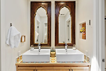Twin contemporary vessel sinks with wood-framed 