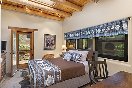 Second bedroom with Santa Fe accents of large Vigas with T&G Latillas, and Stone flooring