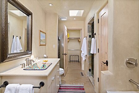 Main bathroom with bathtub and shower, and washer/dryer 