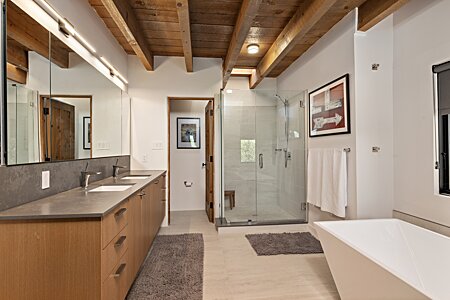 Custom frameless glass walled shower and rift oak cabinetry