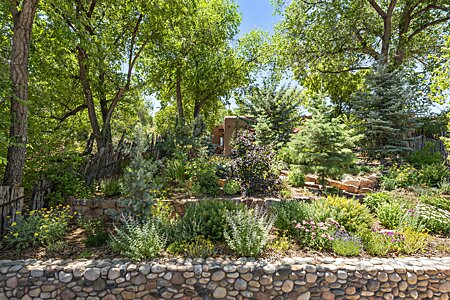 Nestled among magnificent old trees and gardens in the historic South Capitol Santa Fe district