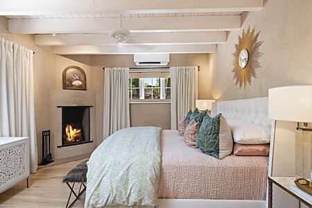 The comfortable primary bedroom includes an updated stylish corner fireplace