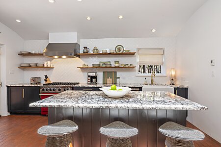 Stylish  Marble; not a budget tile job- it’s to the ceiling!; cool, hardware, and the red Viking stove! WOW!