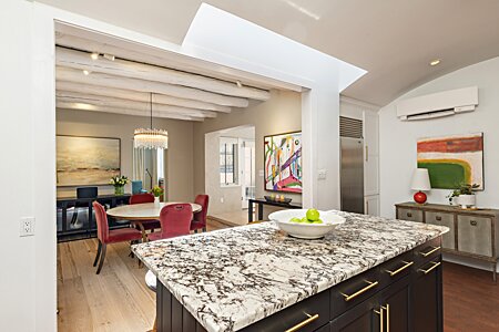 The marble kitchen island opens onto the dining room, with lots of open space, all around