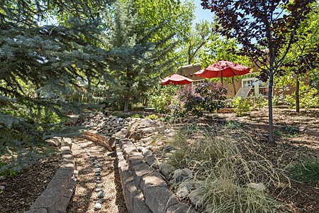 Very special to have a vintage acequia, lined with smooth white and black river rocks gracing one’s property!