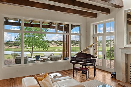Piano is surrounded by windows taking in the Lake & Golf Course Views