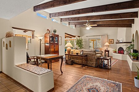 Beautiful large living room featuring wood flooring, Kiva fireplace and beam ceiling