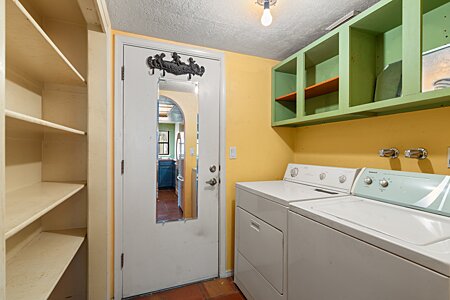 Laundry room with access into two car garage with extra storage