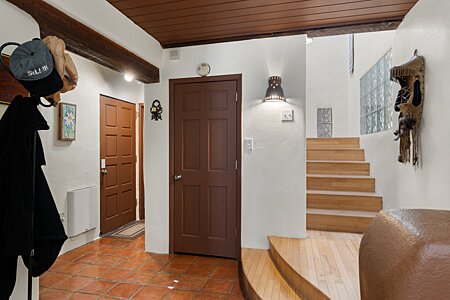 Entry Hall w/ access to garage & Laundry & Stairs up to Living/Dining/Kitchen/Guest Bedroom 2