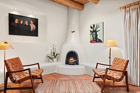 A cozy conversation area with a wood-burning kiva fireplace