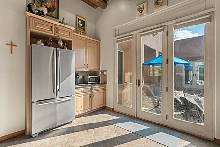 Kitchen refrigerator plus doors to the West Courtyard with Fireplace