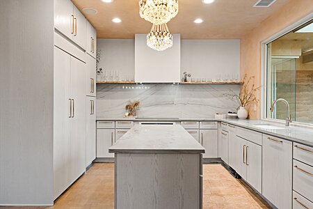 Soothing monochromatic kitchen pallet enhancing the fabulous view!